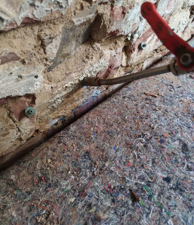 Ein Steinmauer mit einem metallenen Werkzeug und einem farbenfrohen Bodenbelag.